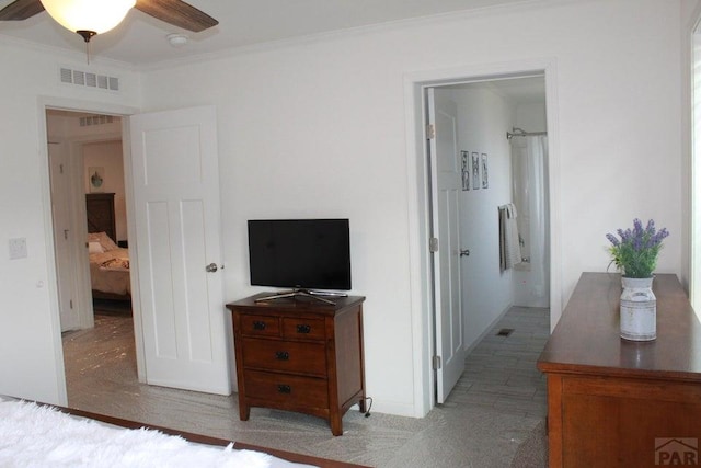 bedroom with visible vents, crown molding, and ensuite bathroom