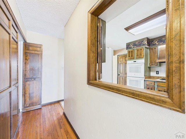 9 Woodsorrel Ct, Pueblo, CO 81001 - hall with hardwood / wood-style flooring, baseboards, and a textured ceiling