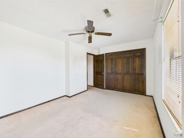 9 Woodsorrel Ct, Pueblo, CO 81001 - unfurnished bedroom with light colored carpet, baseboards, a closet, a textured ceiling, and ceiling fan