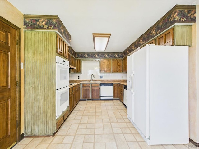 9 Woodsorrel Ct, Pueblo, CO 81001 - kitchen featuring white appliances, a sink, light countertops, and brown cabinets