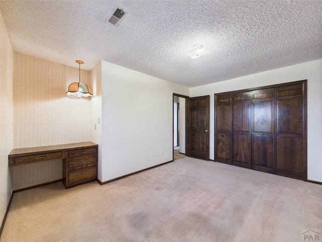 9 Woodsorrel Ct, Pueblo, CO 81001 - unfurnished bedroom with baseboards, light colored carpet, and a textured ceiling