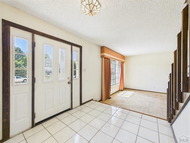 9 Woodsorrel Ct, Pueblo, CO 81001 - entrance foyer featuring light carpet, light tile patterned flooring, and a textured ceiling