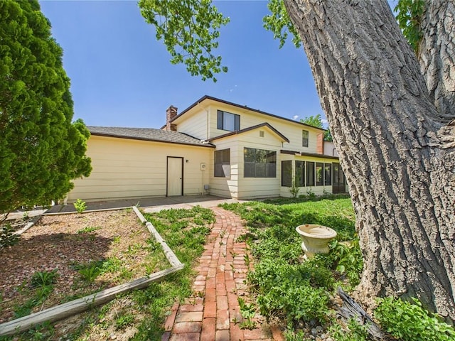 9 Woodsorrel Ct, Pueblo, CO 81001 - back of house featuring a sunroom, a chimney, and a patio