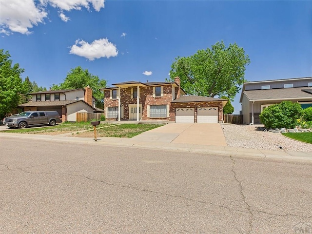 9 Woodsorrel Ct, Pueblo, CO 81001 - view of front of house featuring brick siding, a garage, concrete driveway, and a chimney
