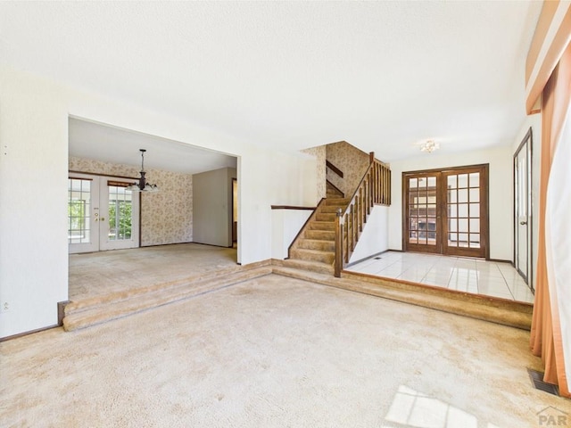 9 Woodsorrel Ct, Pueblo, CO 81001 - unfurnished living room with french doors, carpet flooring, and stairs