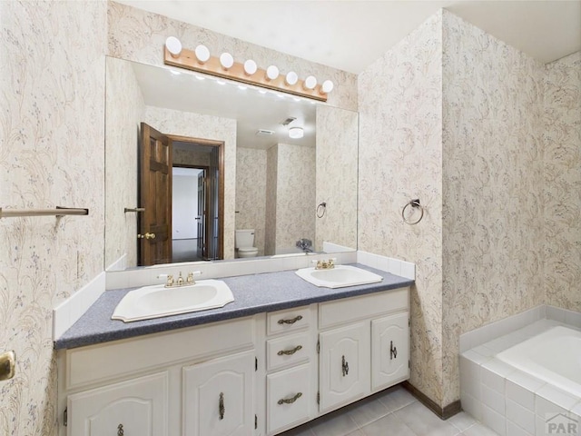 9 Woodsorrel Ct, Pueblo, CO 81001 - full bath featuring tile patterned flooring, double vanity, wallpapered walls, toilet, and tiled bath