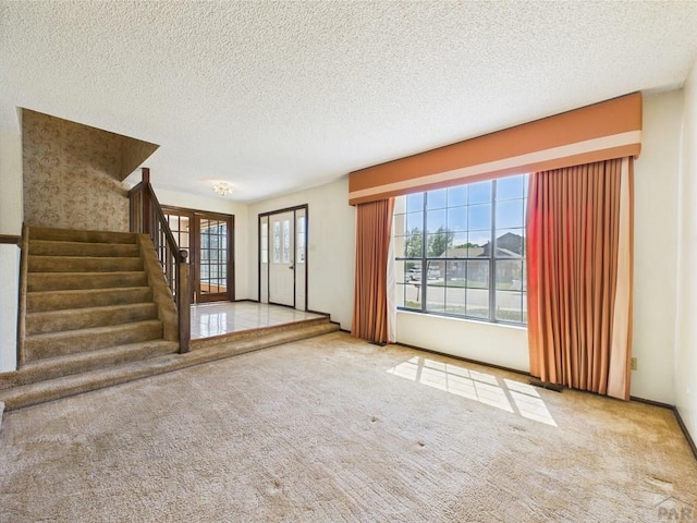 9 Woodsorrel Ct, Pueblo, CO 81001 - unfurnished living room with carpet flooring, stairs, and a textured ceiling