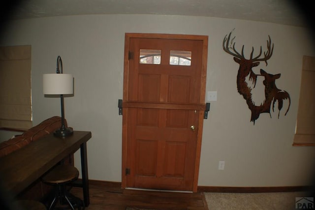 foyer featuring wood finished floors and baseboards