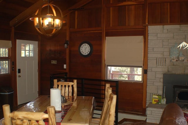 dining space featuring a baseboard radiator, a chandelier, and a wood stove