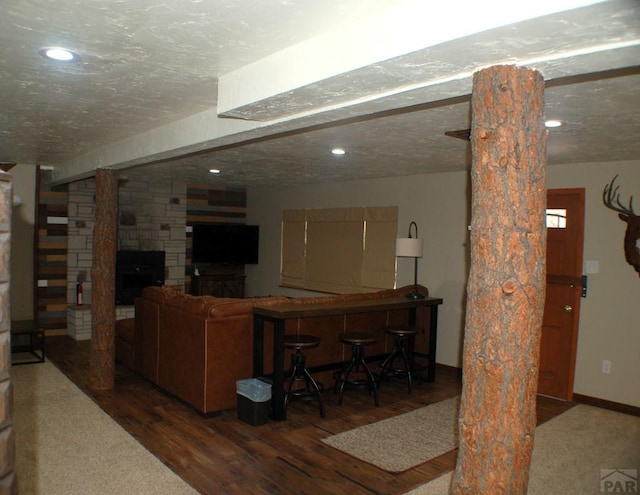 living area featuring recessed lighting, wood finished floors, baseboards, and a textured ceiling