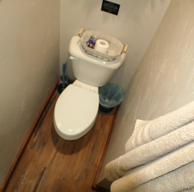 bathroom with toilet and wood finished floors