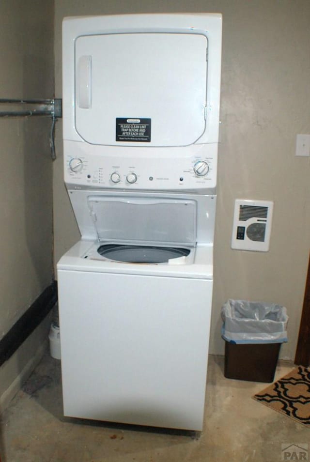 washroom featuring stacked washer / drying machine and laundry area