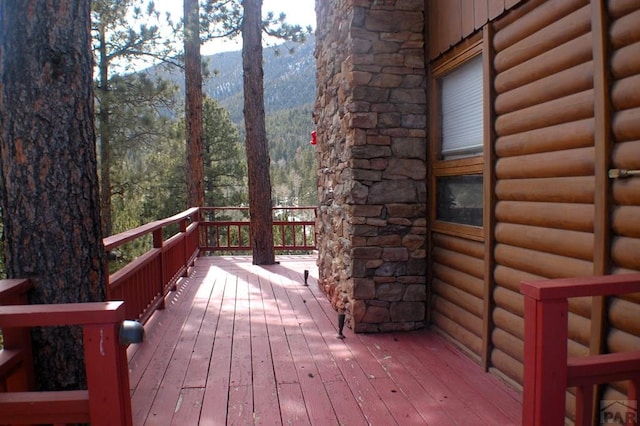 wooden terrace featuring a forest view