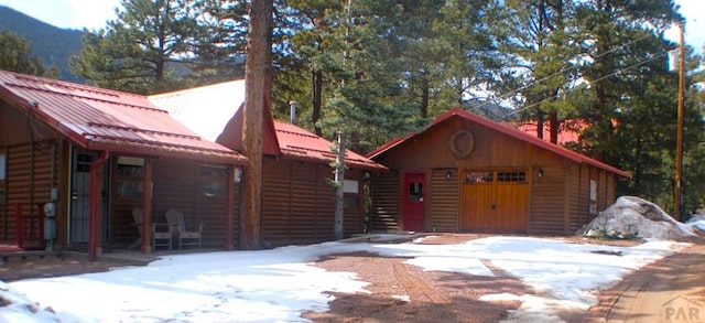 exterior space featuring log veneer siding and metal roof