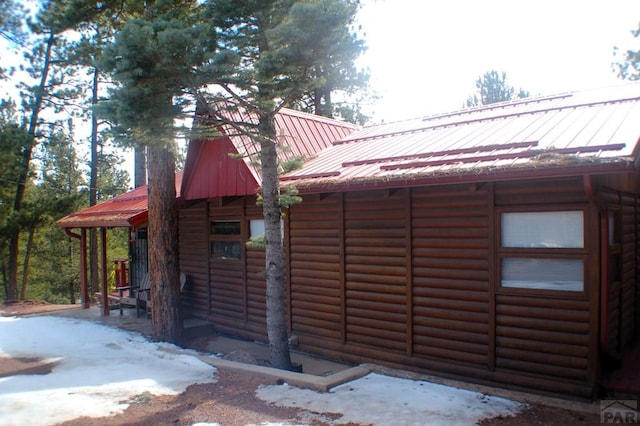 exterior space featuring log veneer siding and metal roof