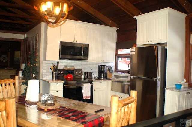 kitchen featuring a chandelier, decorative backsplash, appliances with stainless steel finishes, and vaulted ceiling with beams