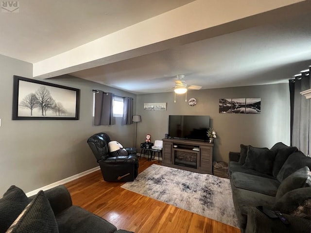 living room featuring ceiling fan, baseboards, and wood finished floors