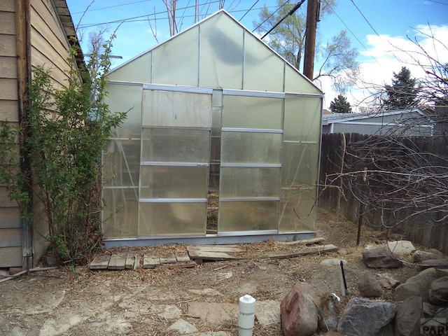 view of greenhouse featuring fence