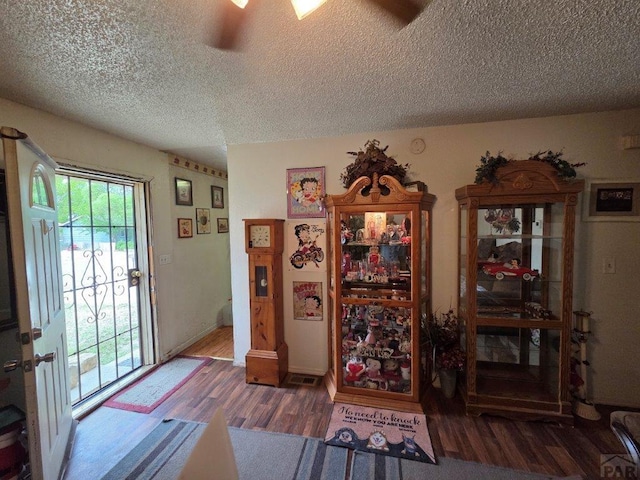 entryway featuring ceiling fan, a textured ceiling, and wood finished floors