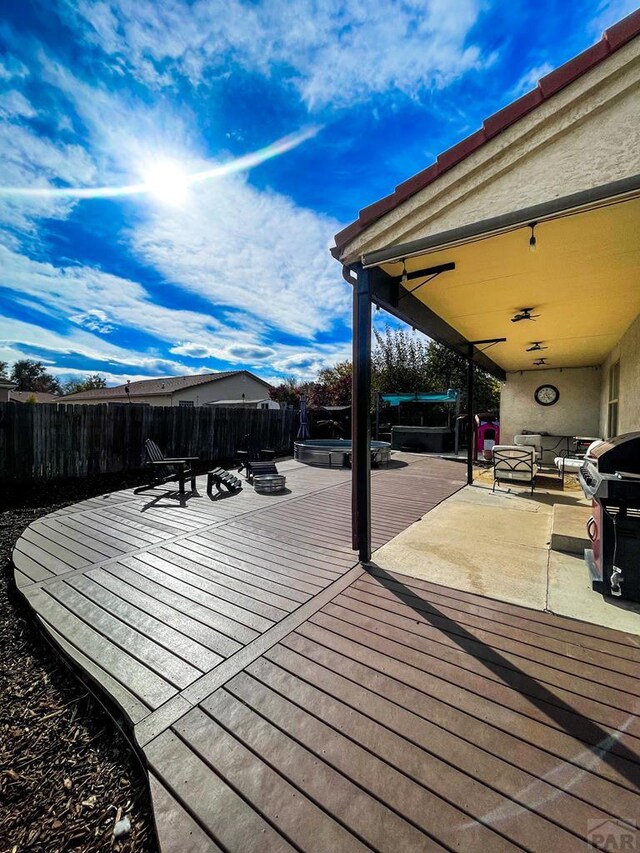 wooden terrace featuring fence private yard and a hot tub