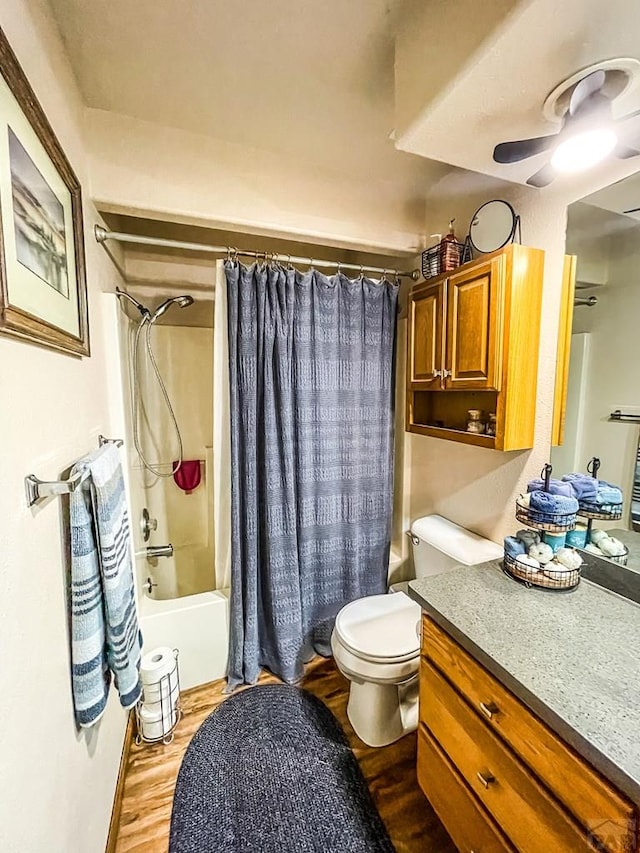 full bathroom featuring toilet, wood finished floors, vanity, a ceiling fan, and shower / bath combination with curtain