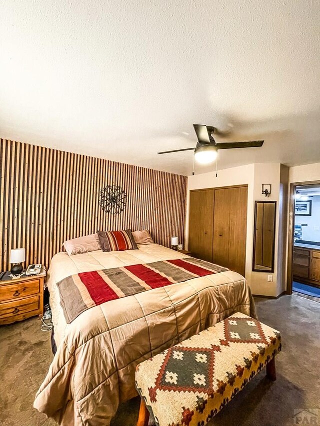 bedroom featuring a closet, dark carpet, a textured ceiling, and ceiling fan