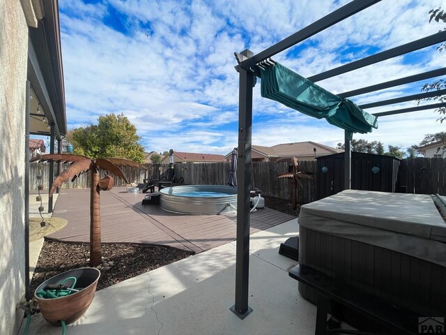 view of patio / terrace featuring a fenced backyard, a covered hot tub, a pool, and a pergola