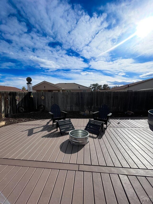 wooden terrace with fence and a fire pit