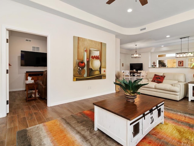 living room featuring a ceiling fan, recessed lighting, visible vents, and dark wood finished floors