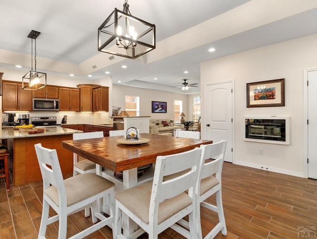 dining area with wood tiled floor, ceiling fan, baseboards, and recessed lighting