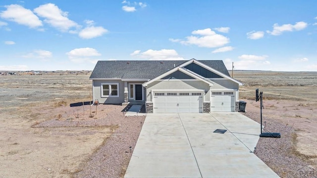 craftsman-style house with a garage, concrete driveway, and stone siding