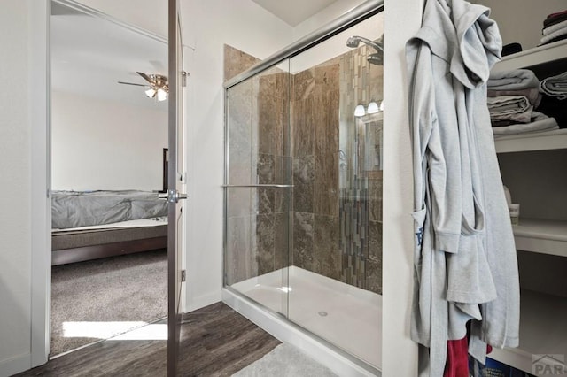 full bathroom with baseboards, a shower stall, ensuite bath, and wood finished floors