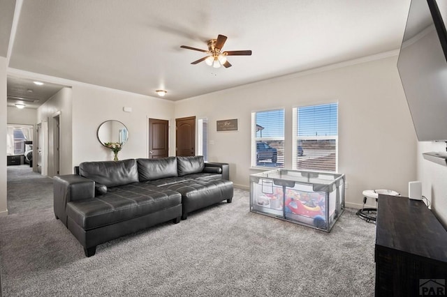 carpeted living area with a ceiling fan, crown molding, and baseboards