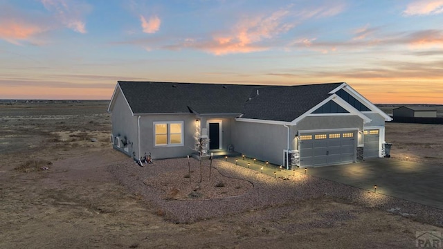 view of front of property with a garage, concrete driveway, and roof with shingles