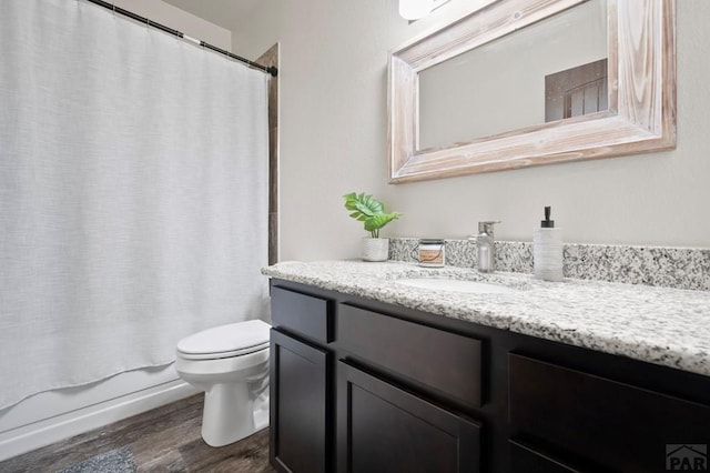 full bathroom featuring vanity, shower / bath combo with shower curtain, wood finished floors, and toilet