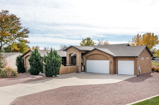 ranch-style home with an attached garage, concrete driveway, and stucco siding