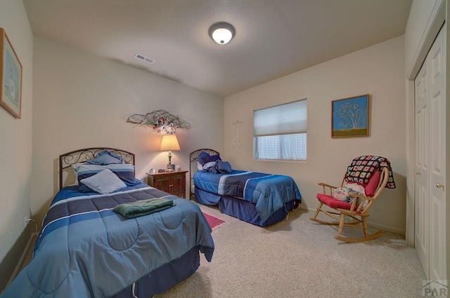 bedroom with a closet, baseboards, visible vents, and carpet floors