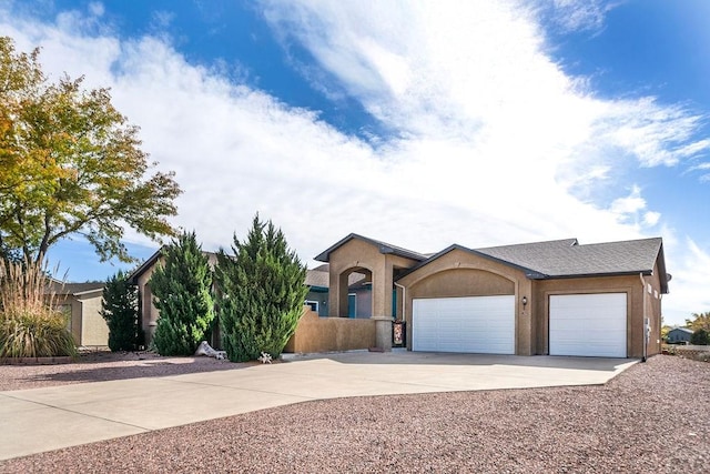 view of front of home featuring concrete driveway, stucco siding, and a garage