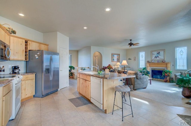 kitchen with open shelves, light brown cabinets, open floor plan, ceiling fan, and stainless steel appliances