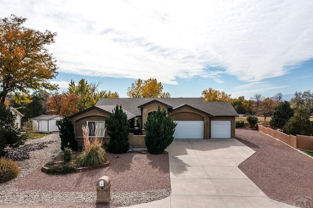 ranch-style home with fence, stucco siding, a garage, and concrete driveway