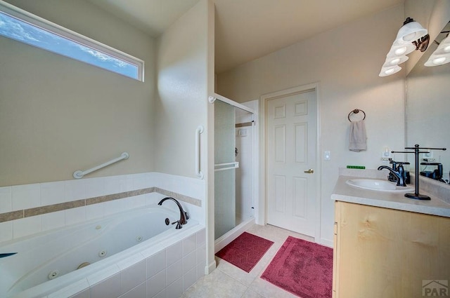 bathroom featuring tile patterned flooring, a jetted tub, a stall shower, and vanity