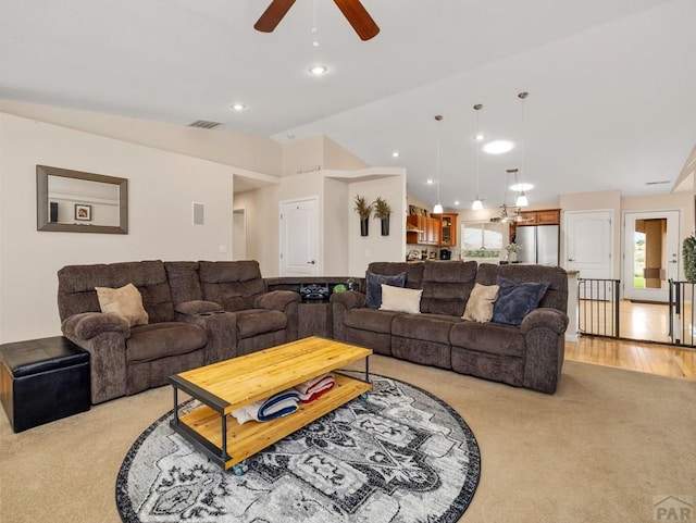 living area featuring light wood-style flooring, visible vents, vaulted ceiling, and recessed lighting