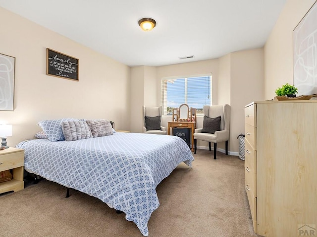 bedroom with baseboards, visible vents, and light colored carpet