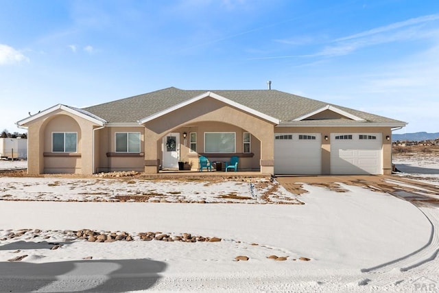 ranch-style home featuring a garage, driveway, a shingled roof, and stucco siding