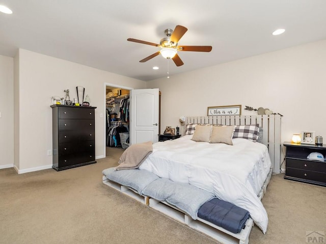 carpeted bedroom with recessed lighting, a closet, a spacious closet, and baseboards