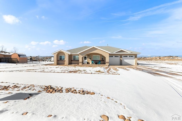 view of front of house with a garage, fence, and stucco siding