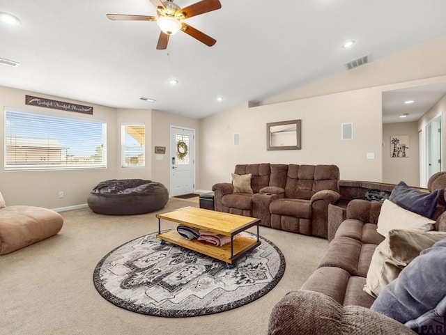 living area with light carpet, visible vents, a ceiling fan, and lofted ceiling