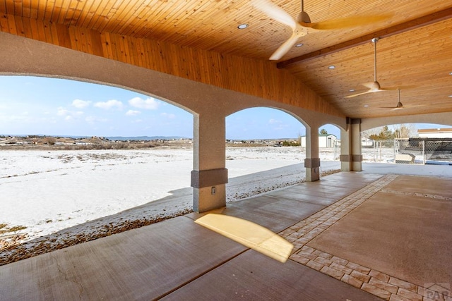 snow covered patio with fence and a ceiling fan