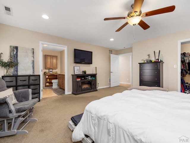 bedroom featuring light carpet, visible vents, a walk in closet, and recessed lighting