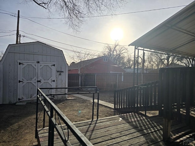 exterior space with an outdoor structure, a deck, a storage shed, and fence